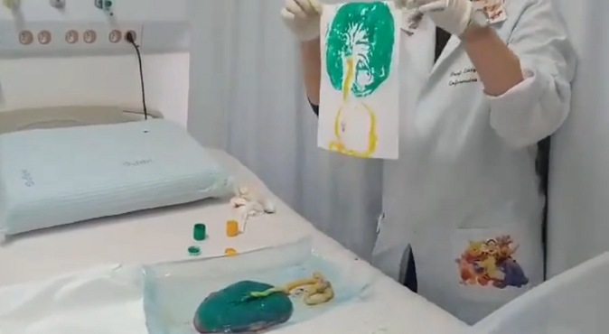 Nessa imagem, obtida de uma reprodução do Youtube, é possível ver a placenta pintada e confecção do carimbo