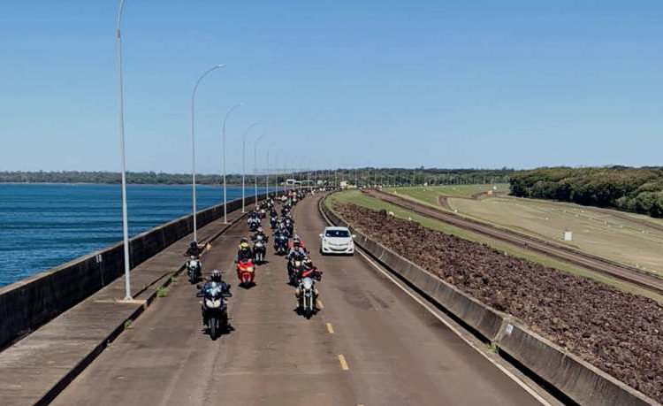 Motociclistas passeiam na crista da barragem de Itaipu. À esquerda, reservatório de Itaipu. Fotos: Turismo Itaipu.