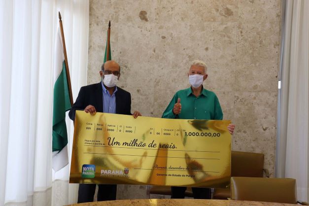 Novo milionário recebe o cheque simbólico. Foto: SEFA/Divulgação