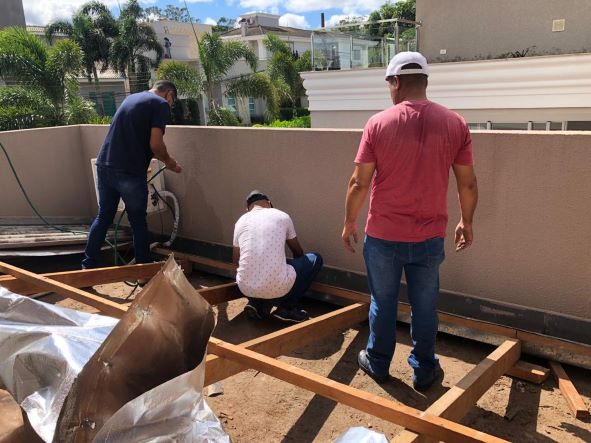 Foto de egressos trabalhando no telhado  da casa de Chico e Rosa. Foto: PMPR/Divulgação