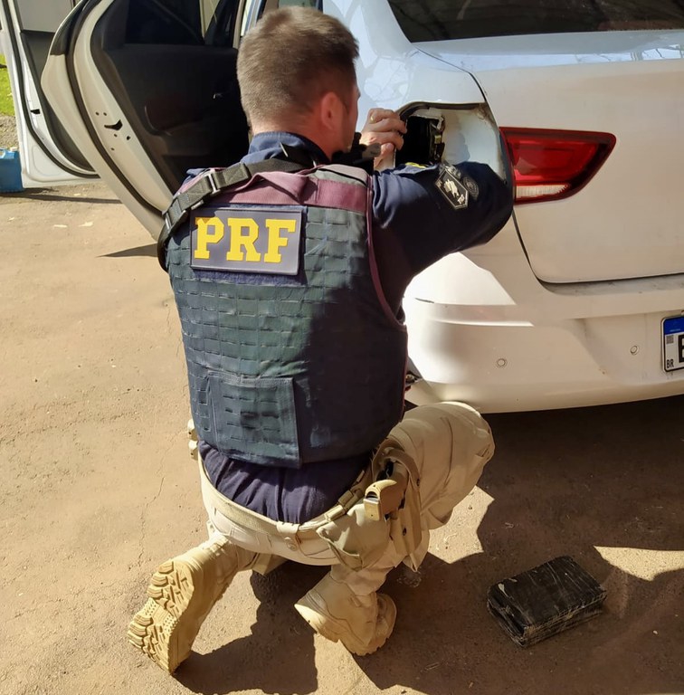 Cocaína sendo retirado veículo pela lanterna traseira quebrada. Foto: divulgação/PRF