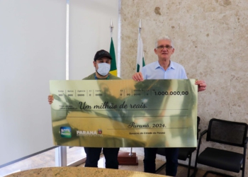 De boné e máscara para evitar ser reconhecido, ele recebeu o cheque simbólico do secretário estadual da Fazenda, Norberto Ortigara, nesta terça-feira (10)
Foto: SEFA-PR